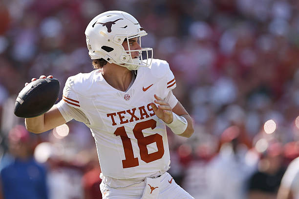 A college football player wearing a white Texas jersey with the number 16 is in the process of throwing a football during a game.
